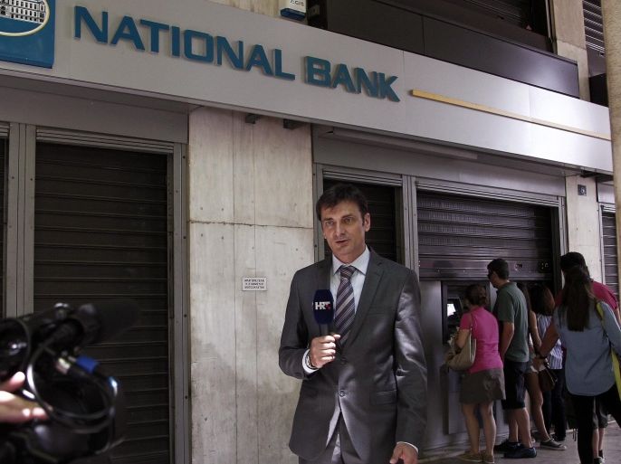 A Croatian reporter stands infront a queue of people waiting to withdraw money from an ATM outside a branch of Greece's National Bank in Athens, Greece, 28 June 2015. Greek Prime Minister Alexis Tsipras called for a referendum on the Greek debt deal on 05 July, during a televized speech on Greek state TV. Eurozone finance ministers on 27 June rejected a request to extend the European part of Greece's bailout program beyond 30 June, casting serious doubts on the Mediterranean nation's permanence in the European common currency.