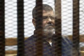 Deposed Egyptian President Mohamed Mursi listens to his verdict behind bars at a court on the outskirts of Cairo, Egypt June 16, 2015. An Egyptian court sentenced Mursi to death on Tuesday on charges of killing, kidnapping and other offences during a 2011 mass jail break.The general guide of the Muslim Brotherhood, Mohamed Badie, and four other Brotherhood leaders were also handed the death penalty. More than 80 others were sentenced to death in absentia. REUTERS/Asmaa Waguih