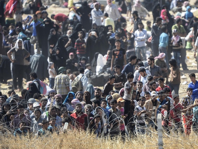 حشود النازحين تتجمع عند الحدود التركية هربا من التهديدات في تل أبيض (غيتي)