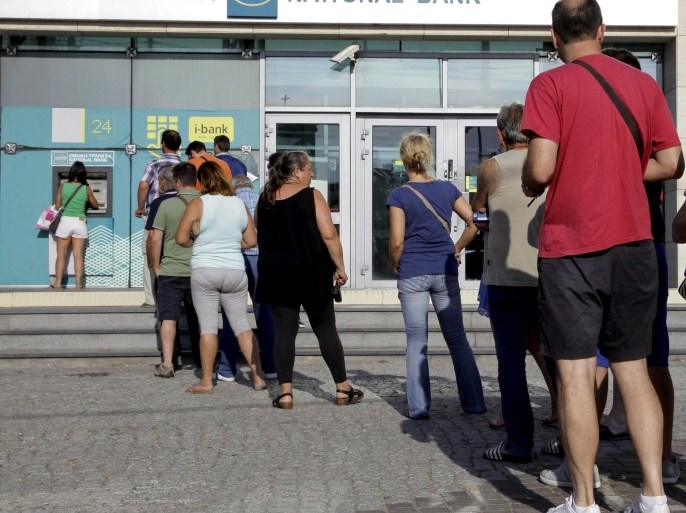 People line up to withdraw cash from an automated teller machine (ATM) outside a National Bank branch in Iraklio on the island of Crete, Greece June 28, 2015. Greece's Prime Minister Alexis Tsipras on Sunday announced a bank holiday and capital controls after Greeks responded to his surprise call for a referendum on bailout terms by pulling money out of banks. REUTERS/Stefanos Rapanis