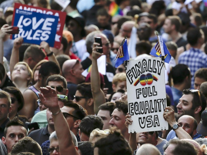 Demonstrators gather at a rally in Greenwich Village to celebrate the Supreme Court's ruling on gay marriage, Friday, June 26, 2015, in New York. The Supreme Court declared Friday that same-sex couples have a right to marry anywhere in the U.S. (AP Photo/Julie Jacobson)