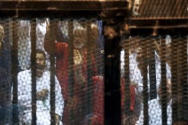 Mohamed Badie (C, in red), the general guide of the Muslim Brotherhood, and other Muslim Brotherhood members gesture behind bars after their verdict at a court on the outskirts of Cairo, Egypt June 16, 2015. An Egyptian court sentenced deposed President Mohamed Mursi to death on Tuesday on charges of killing, kidnapping and other offences during a 2011 mass jail break.The general guide of the Muslim Brotherhood, Mohamed Badie, and four other Brotherhood leaders were also handed the death penalty. More than 80 others were sentenced to death in absentia. REUTERS/Asmaa Waguih