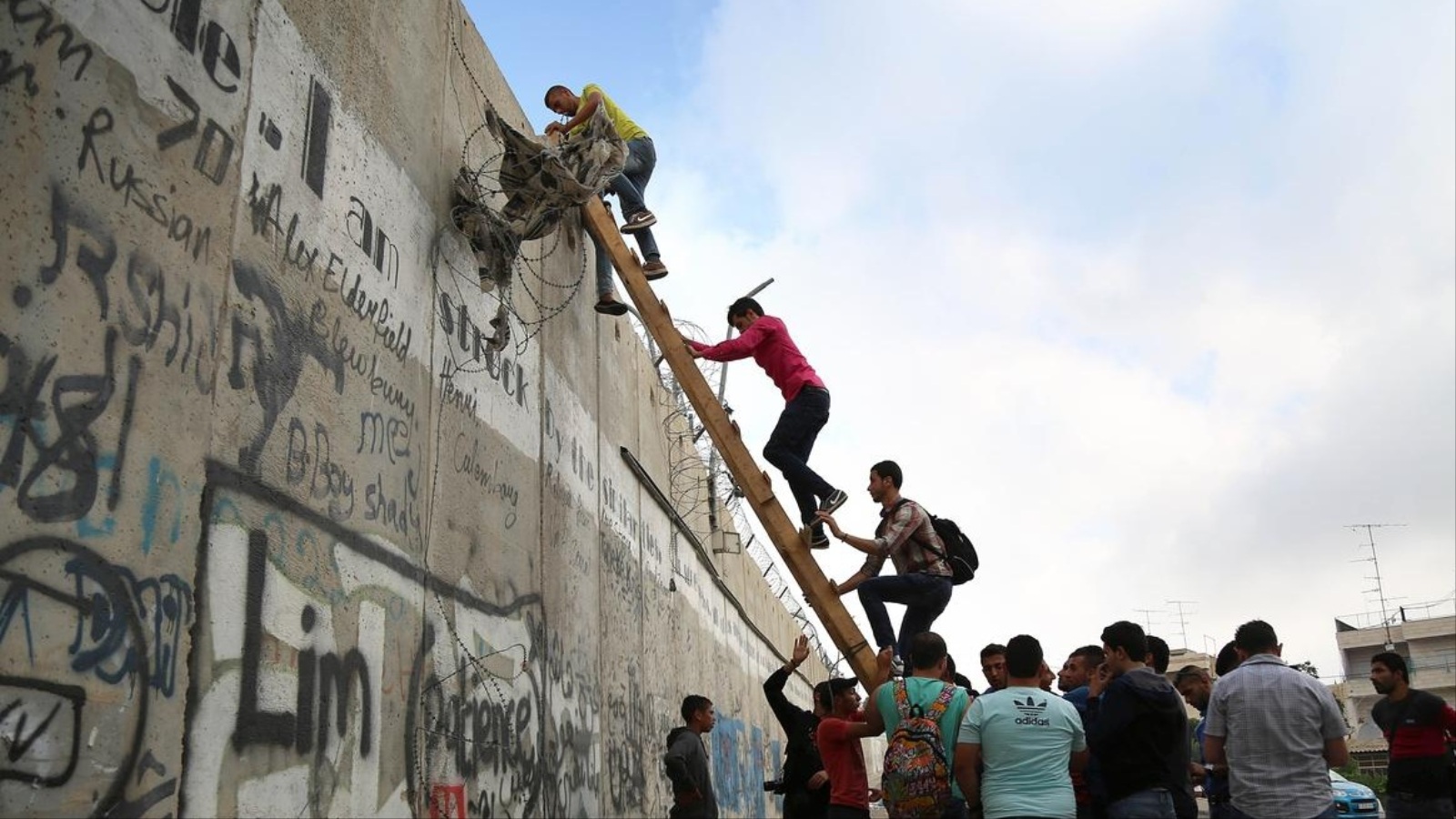 ‪فلسطينيون يتسلقون جدار الفصل الإسرائيلي لتأدية صلاة الجمعة الثانية في شهر رمضان‬  (وكالة الأناضول)