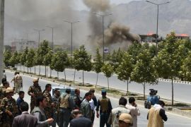 Afghan security personnel and bystanders look on as black smoke billows from the Afghan Parliament building in Kabul on June 22, 2015, during an attack in the Afghan capital. Taliban militants attacked the Afghan parliament on June 22, with gunfire and explosions rocking the building, sending lawmakers running for cover in chaotic scenes relayed live on television.The insurgents tried to storm the complex after triggering a car bomb but were repelled and have taken position in a partially-constructed building nearby, officials said about the ongoing attack. All MPs were safely evacuated after the attack, which came as the Afghan president's nominee for the crucial post of defence minister was to be introduced in parliament. AFP PHOTO / SHAH Marai
