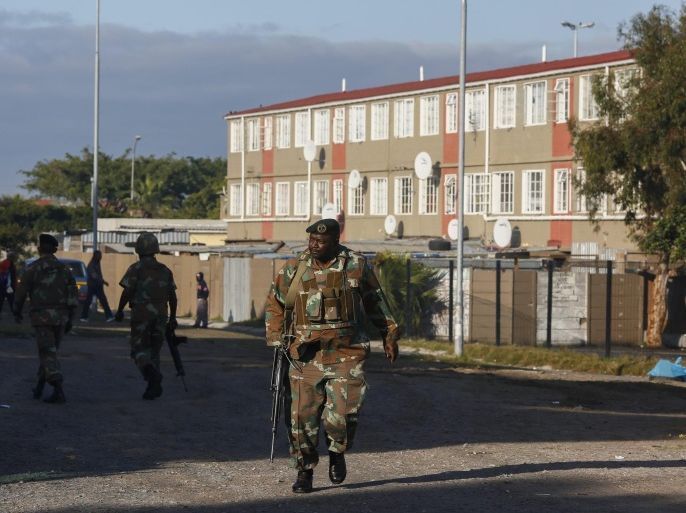 South African Defence Force soldiers secure a perimiter around a hostel in Manenberg as police conduct an operation involving house to house raids in the gang ridden area of Manenberg, on the Cape Flats of Cape Town, South Africa 21 May 2015. Western Cape police said the operation was part of a wider scheme to clamp down on criminal and gang violence in the area. More raids are expected in the Cape's gang hotspots as the integrated crime prevention operation will focus on drugs, illegal firearms and other criminal activities according to police.