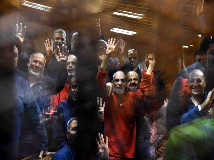 Muslim Brotherhood Supreme Guide Mohammed Badie (C, wearing red) along other Brotherhood members react inside defendants' cage in the courtroom during a trial session, in Cairo, Egypt, 16 June 2015. A Cairo court on 16 June 2015 sentenced former president Mohamed Morsi to death over jailbreaks during Egypt's 2011 uprising. Muslim Brotherhood Supreme Guide Mohammed Badie, former parliament speaker Saad al-Katatni and three other co-defendants also received the death penalty in the case. In a related case, three Muslim Brotherhood leaders were sentenced to hang for conspiring with foreign powers. Morsi and 16 others received life sentences in that case. EPA/ALI MALKI / ALMASRY ALYOUM EGYPT OUT