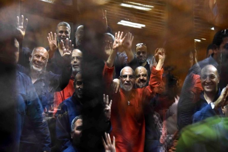 Muslim Brotherhood Supreme Guide Mohammed Badie (C, wearing red) along other Brotherhood members react inside defendants' cage in the courtroom during a trial session, in Cairo, Egypt, 16 June 2015. A Cairo court on 16 June 2015 sentenced former president Mohamed Morsi to death over jailbreaks during Egypt's 2011 uprising. Muslim Brotherhood Supreme Guide Mohammed Badie, former parliament speaker Saad al-Katatni and three other co-defendants also received the death penalty in the case. In a related case, three Muslim Brotherhood leaders were sentenced to hang for conspiring with foreign powers. Morsi and 16 others received life sentences in that case. EPA/ALI MALKI / ALMASRY ALYOUM EGYPT OUT