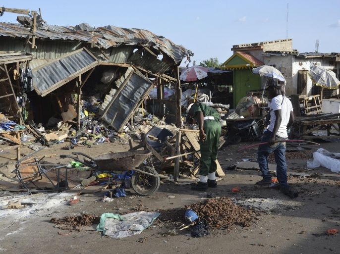 People gather at the site of a suicide bomb attack at a market in Maiduguri, Nigeria, Monday June 22, 2015. Two girls blew themselves up on Monday near a crowded mosque in northeast Nigeria's biggest city, killing about 30 people, witnesses said. It is the fourth suicide bombing this month in Maiduguri, which is the birthplace of the Boko Haram Islamic extremist group. (AP Photo/Jossy Ola)