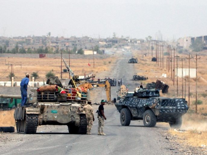 A picture made available 31 May 2015, shows Iraqi forces advancing during the clashes with fighters from the group calling themselves the Islamic State (IS) near Baiji, northern Iraq, 29 May 2015. According to Iraqi officials Iraqi troops backed by Shiite volunteers have made significant gains in their offensive against IS around the Baiji refinery, about 200 kilometres north of Baghdad, which accounts for almost a third of all Iraqi oil production but has not been functional since IS advances in 2014.