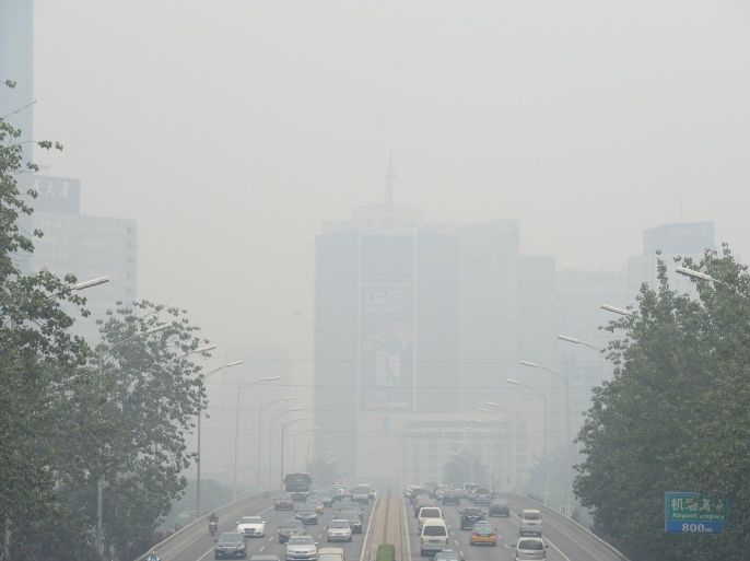 This picture taken on June 23, 2015 shows vehicles running in smog covered streets in Beijing. China's cities are often hit by heavy pollution, blamed on coal-burning by power stations and industry, as well as vehicle use. The issue has become a major source of popular discontent with the Communist Party, leading the government to vow to reduce the proportion of energy derived from fossil fuels. CHINA OUT AFP PHOTO
