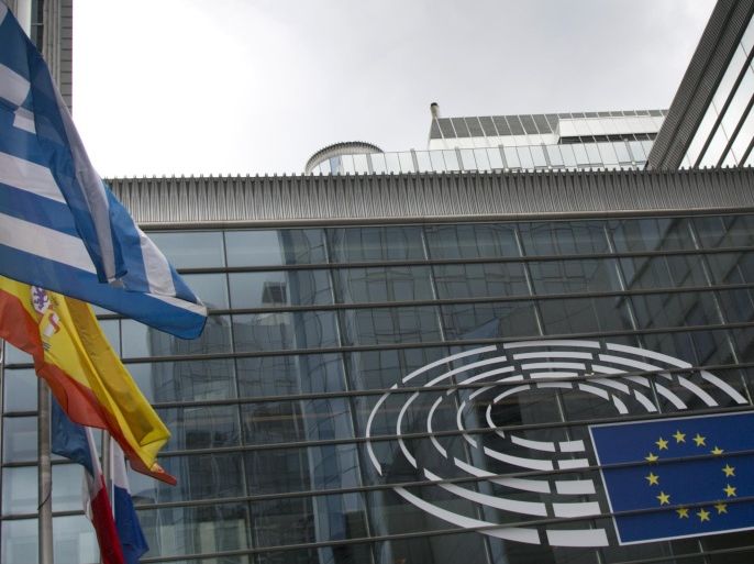 The Greek flag, left, flaps in the wind outside the European Parliament in Brussels on Monday, June 15, 2015. U.S. stocks are opened lower Monday after weekend talks between Greece and its creditors stalled, raising the possibility the country could default. (AP Photo/Virginia Mayo)