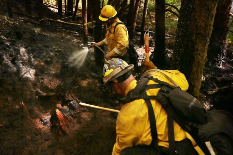 Don Scriven, left, and Jason Campbell with First Strike Environmental out of Roseburg, Oregon work to widen the fire line on the west flank of the Yellow Point Fire west of Cottage Grove, Oregon Tuesday Sept. 9, 2014. Strategically placed fire cameras helped firefighters get an early jump on containing this fire. (AP Photo/The Register-Guard, Chris Pietsch)