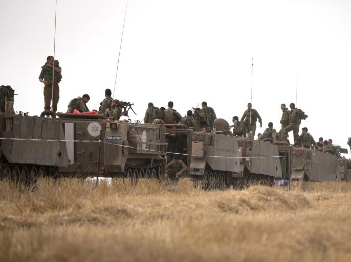 Israeli soldiers stand on armored personal carriers during a training exercise near the Israel-Gaza Border, on June 7, 2015. Israeli warplanes struck Gaza earlier in the day for the second time in three days after cross-border rocket fire by an Islamic extremist group which is locked in a power struggle with Hamas. AFP PHOTO / MENAHEM KAHANA