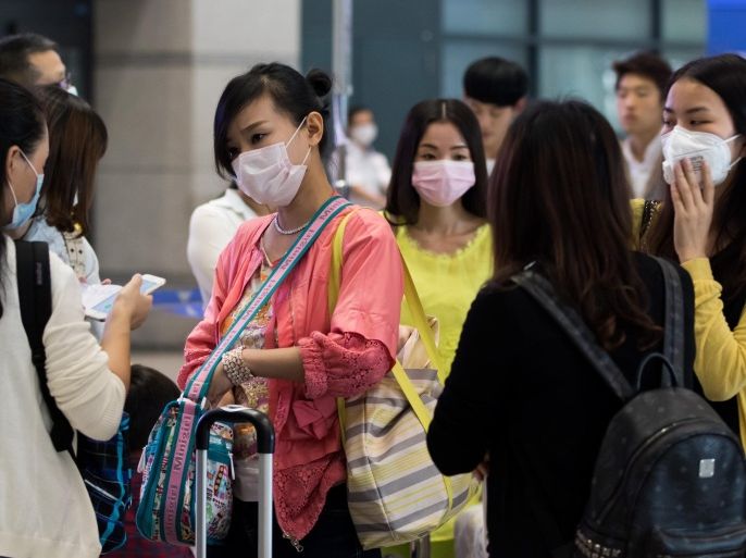 Chinese tourists wearing face masks stand at Incheon International Airport in Incheon, South Korea, on Monday, June 8, 2015. South Korea reported its sixth death from the Middle East respiratory syndrome (MERS), with the total number of cases rising to 87, including the first teenager to be infected with the virus.