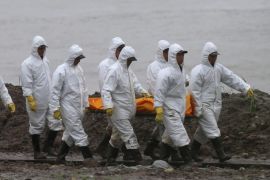 Rescuers carry a victim's body along the Yangtze River as they search for missing passengers of a capsized tourist ship in Jianli, Hubei province, China, 03 June 2015. There were 458 people on the ship, mostly aged tourists, when the ship turned upside down in the Yangtze River on 01 June night in Hubei province. At least 14 people were rescued so far, including three from inside the ship.