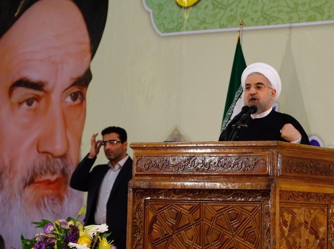 In front of a huge poster showing a portrait of the late Iranian supreme leader Ayatolah Ruhollah Khomeini, Iran's president Hassan Rowhani (R) delivers his speech on the occasion of the 26th death anniversary of Ayatollah Ruhollah Khomeini, at the shrine for Khomeini in southern Tehran, Iran, 03 June 2015. Khomeini was a religious figure who lead the 1979 revolution and was the country's Supreme Leader until his death in 1989. Media reports cited Rowhani as saying that enemies could not slow down Iran's progress by putting sanctions against the country referring to Iran's nuclear program.