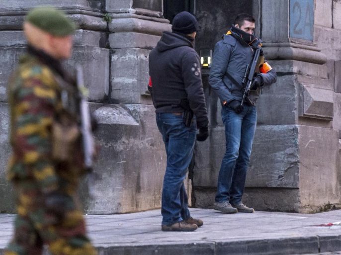 FILE - In this Wednesday, Jan. 21, 2015 file photo, a Belgian para-commando and anti-terror squad policemen guard the parking area at the Palace of Justice, where suspects wanted in Belgium on terrorism-related charges have to appear before the federal court in Brussels. On Monday June 8, 2015 Belgian police arrested 16 people in twin terrorism-related investigations involving Chechen extremists, authorities said. Members of one group, based in western Flanders, were allegedly active in Syria and probably participated in combat there, prosecutors said. (AP Photo/Geert Vanden Wijngaert, File)