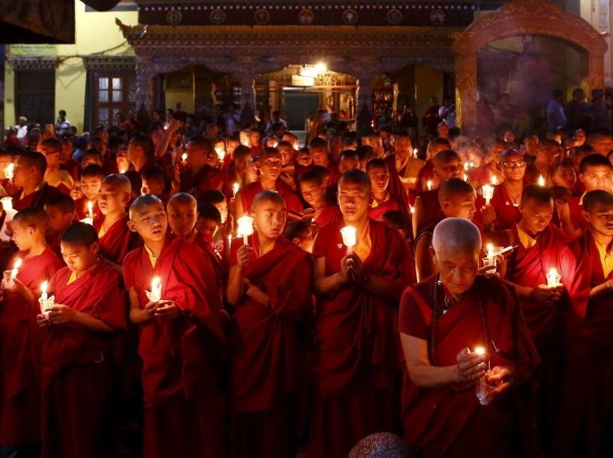 Buddhist monks holding candles offer prayers for the victims of earthquakes in Kathmandu, Nepal June 12, 2015. REUTERS/Navesh Chitrakar TPX IMAGES OF THE DAY TPX IMAGES OF THE DAY