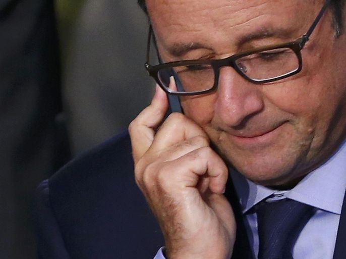 French President Francois Hollande uses his mobile phone as he attends the NATO summit at the Celtic Manor resort, near Newport, in Wales September 4, 2014. French President Francois Hollande said on Friday he would stay in office until the end of his mandate in 2017 despite his record low opinion poll ratings, and defended himself vigorously against a suggestion he disliked the poor. Picture taken September 4, 2014. REUTERS/Yves Herman (BRITAIN - Tags: MILITARY POLITICS)