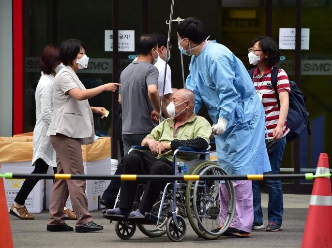 A South Korean medical worker wearing protective clothing moves a man (C) suspected of carrying MERS virus in front of the emergency section at the Samsung Medical Centre in Seoul on June 8, 2015. South Korea recorded its sixth death and biggest single day jump in Middle East Respiratory Syndrome (MERS) infections on June 8, with 23 new cases in the largest outbreak of the potentially deadly virus outside Saudi Arabia. Among the 23 new cases, 17 were infected at the Samsung Medical Centre in southern Seoul, the health ministry said. AFP PHOTO / JUNG YEON-JE
