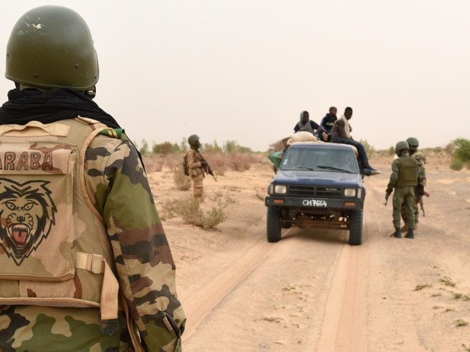 Malian army forces control civilians vehicles on June 4, 2015, near Goundam 80 km east of Timbuktu, central Mali as they patrol during a joint operation 'La Madine 3' with French soldiers of the 93 th Regiment d'Artillerie de Montagne (based in Vars, southeastern France) of Operation Barkhane, an anti-terrorist operation in the Sahel. AFP PHOTO / PHILIPPE DESMAZES