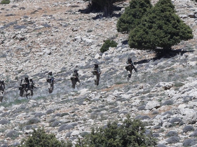Lebanon's Hezbollah fighters carry their weapons as they walk in Khashaat, in the Qalamoun region after they advanced in the area May 15, 2015. When Lebanon's Hezbollah first joined Syria's war on the side of President Bashar al-Assad, its role was a closely guarded secret. Today, as Hezbollah plants its flag in land won from rebels north of Damascus, its role could hardly be more public. Picture taken May 15, 2015. To match Insight MIDEAST-CRISIS/SYRIA REUTERS/Mohamed Azakir