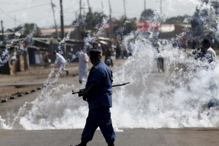 A policeman walks after throwing a teargas canister during a protest against Burundi President Pierre Nkurunziza and his bid for a third term in Bujumbura, Burundi, June 2, 2015. REUTERS/Goran Tomasevic