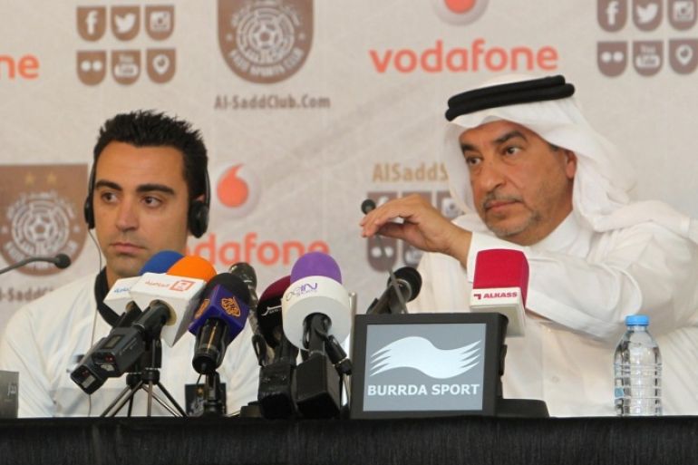 Barcelona legend Xavi Hernandez (L) speaks to the press with Jassim Al Rumaihi, Secretary General of Al-Sadd football club, (2R) after signing a two-year contract with Qatar's Al-Sadd team in Doha on June 11, 2015. AFP PHOTO / STR