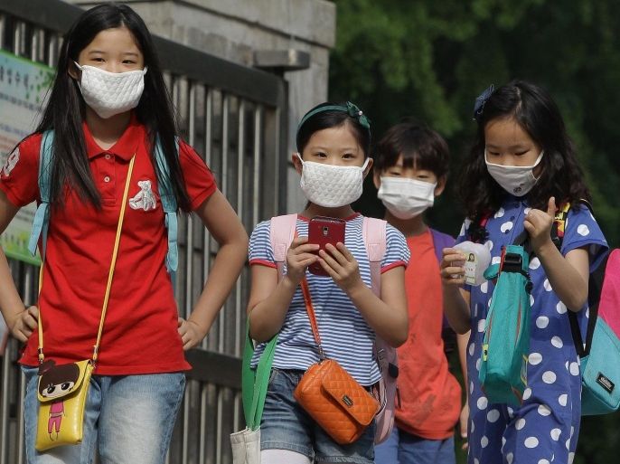 SEOUL, SOUTH KOREA - JUNE 09: Elementary school students wear masks as a precaution against the MERS virus as they arrive at Midong Elementary School on June 9, 2015 in Seoul, South Korea. South Korea has reported eight deaths related to the virus with 2,500 people quarantined and 1,800 schools closed as of June 9, 2015.