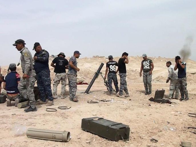 In this Saturday, June 20, 2015 photo, Iraqi security forces fire mortar shells at Islamic State group positions on the outskirts of Ramadi, the capital of Iraq's Anbar province, 115 kilometers (70 miles) west of Baghdad. The forces in Ramadi have been fighting against the IS group over a month since the city fell for the second time to the extremists. (AP Photo)