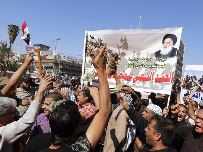 Iraqis hold banners bearing portrait of Iraq's top Shiite cleric Grand Ayatollah Ali al-Sistani during a demonstration in support of the Popular Mobilisation units' fight against the Islamic State (IS) group in Baghdad's central Tahrir Square on March 14, 2015. AFP PHOTO / SABAH ARAR