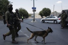 Israeli soldiers stand guard at a checkpoint between Jerusalem and West Bank city Bethlehem on June 29, 2015, after a Palestinian woman stabbed a female Israeli soldier in the neck. The suspected assailant was detained at the scene, and two other knives were found in her possession, police added. AFP PHOTO/AHMAD GHARABLI