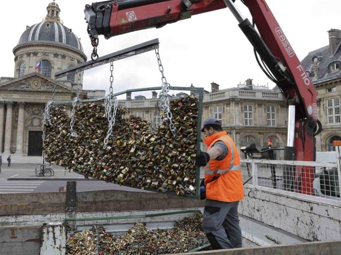 A workman places an iron grill panel covered with "love locks" from the Pont des Arts into a truck in Paris, France, June 1, 2015. The bridge is closed from June 1 to June 8 and the iron grills covered with padlocks which hang on the 19th century pedestrian bridge will be removed by city municipal employees. The pedestrian bridge has become a shrine for love declarations by tourists and Parisians alike, who seek to immortalise their love by leaving an initialled padlock attached to its metallic grid railings. REUTERS/Philippe Wojazer
