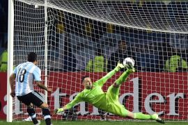 Argentina's forward Carlos Tevez (L) scores the winning penalty kcik past Colombia's goalkeeper David Ospina during the 2015 Copa America football championship quarterfinal match in Vina del Mar, Chile on June 26, 2015. Argentina won 5-4 in penalty shootout. AFP PHOTO / LUIS ACOSTA