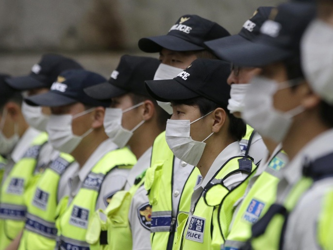 ‪‬ عناصر من قوات الشرطة الكورية الجنوبية يرتدون أقنعة للحماية من فيروس كورونا(أسوشيتد برس)