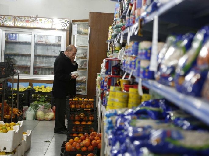 A man shops at a consumer corporation affiliated to the Ministry of Internal Trade in Damascus February 22, 2015. The Syrian government does not expect to import wheat this year because domestic grain supplies will be boosted by heavy rainfall and wider control over farmland, a minister said. Hassan Safiyeh, the minister of internal trade and consumer protection, also told Reuters that a credit line extended by Iran to its Syrian ally had been unaffected by the collapse in world oil prices and fuel imports continued. Safiyeh's ministry oversees the provision of heavily subsidised foodstuffs and fuel to Syrians in areas of government control, making it a vital arm of the state in a country about to enter its fifth year of conflict. The state has lost control of oilfields and wide areas of agricultural land seized by insurgents during the conflict that has devastated the economy. REUTERS/Omar Sanadiki (SYRIA - Tags: POLITICS CIVIL UNREST CONFLICT FOOD)