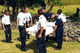 Police and gendarmes carry a piece of debris from an unidentified aircraft found in the coastal area of Saint-Andre de la Reunion, in the east of the French Indian Ocean island of La Reunion, on July 29, 2015. The two-metre-long debris, which appears to be a piece of a wing, was found by employees of an association cleaning the area and handed over to the air transport brigade of the French gendarmerie (BGTA), who have opened an investigation. An air safety expert did not exclude it could be a part of the Malaysia Airlines flight MH370, which went missing in the Indian Ocean on March 8, 2014. AFP PHOTO / YANNICK PITOU