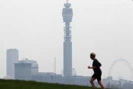 LONDON, ENGLAND - APRIL 03: A woman runs to the top of Primrose Hill, with the London skyline in the background on April 3, 2014 in London, England. Dust from the Sahara combined with pollution from mainland Europe has contributed to one of the worst smogs of the year this week with record levels being recorded in parts of England and as a consequence 999 have been receiving a rise in calls from people suffering from breathing problems.