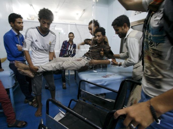 Fighters of the Popular Resistance Committees help a comrade at a hospital after he was injured during clashes with Houthi fighters in Yemen's southwestern city of Taiz July 8, 2015. REUTERS/Stringe