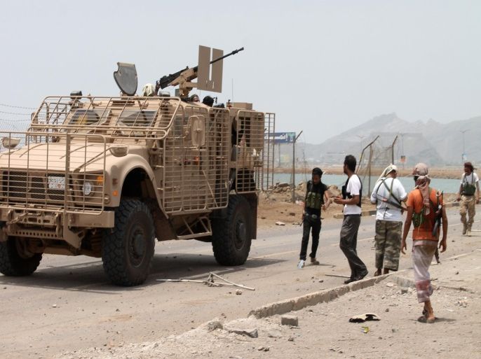 Armed militiamen loyal to Yemen's fugitive President Abderabbo Mansour Hadi stand next to an armed vehicle in the Khor Maskar neighbourhood of the southern Yemeni city of Aden on July 14, 2015 near Aden's airport which they recaptured from Shiite Huthi rebels. Loyalists of Yemen's exiled president recaptured the airport in second city sealing a four-month battle with Iran-backed rebels with Saudi-led air and naval support, military sources said. AFP PHOTO / SALEH AL-OBEIDI