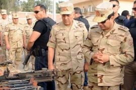 Egypt's President Abdel Fattah al-Sisi (R) inspects weapons taken from Islamist militants after travelling to inspect the Egyptian armed forces in the troubled northern part of the Sinai peninsula in this July 4, 2015 handout photo by the Egyptian Presidency. Egypt launched air strikes in North Sinai on Saturday, killing 12 militants, security sources said, and Sisi visited the restive province where the bloodiest fighting in years erupted earlier this week. REUTERS/The Egyptian Presidency/Handout via ReutersATTENTION EDITORS - THIS PICTURE WAS PROVIDED BY A THIRD PARTY. THIS PICTURE IS DISTRIBUTED EXACTLY AS RECEIVED BY REUTERS, AS A SERVICE TO CLIENTS. EDITORIAL USE ONLY. NOT FOR SALE FOR MARKETING OR ADVERTISING CAMPAIGNS. NO SALES. NO ARCHIVES.