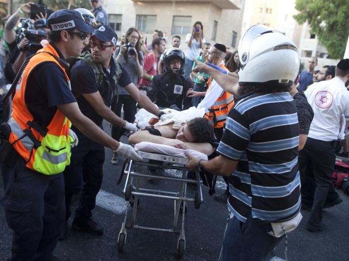 JERUSALEM, ISRAEL - JULY 30: An wounded an Israeli man receives treatment during the Gay Pride Parade on July 30, 2015 in Jerusalem, Israel. At least six people were stabbed at Jerusalem's annual Gay Pride Parade on Thursday. The assailant, an ultra-Orthodox Jew, emerged behind the marchers and began stabbing them while screaming. A police officer then managed to tackle him to the ground and arrest him.
