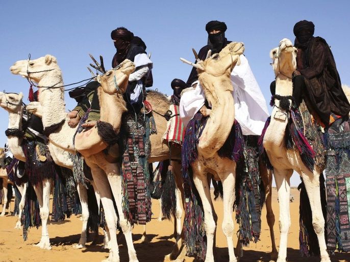 Tuareg men ride camels in the desert during the 19th Ghat Festival of Culture and Tourism, in Ghat, about 1,360 km (845 miles) south of Tripoli December 30, 2013. In the annual event, Tuareg tribes from the region and tourists meet to celebrate Tuareg traditional culture, folklore and heritage. Picture taken December 30, 2013. REUTERS/Esam Omran Al-Fetori (LIBYA - Tags: TRAVEL SOCIETY ANIMALS)