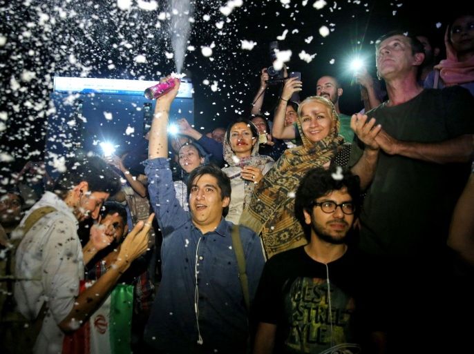 A group of jubilant Iranians cheer and spray artificial snow during street celebrations following a landmark nuclear deal, in Tehran, Iran, Tuesday, July 14, 2015. After long, fractious negotiations, world powers and Iran struck an historic deal Tuesday to curb Iran's nuclear program in exchange for billions of dollars in relief from international sanctions - an agreement aimed at averting the threat of a nuclear-armed Iran and another U.S. military intervention in the Middle East. (AP Photo/Ebrahim Noroozi)