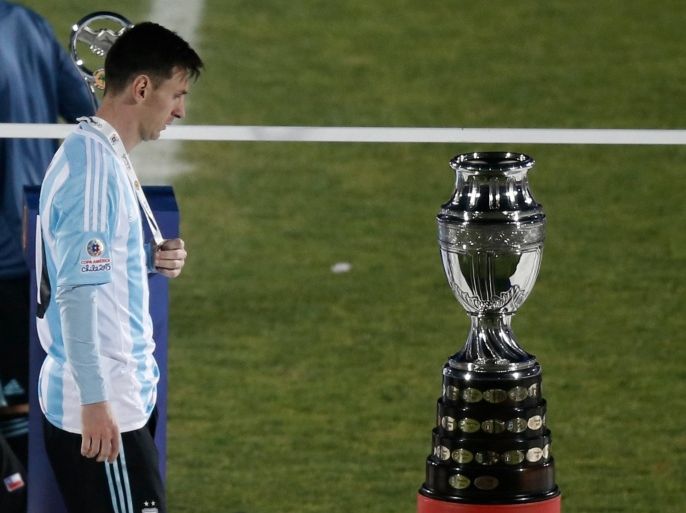 Argentina's Lionel Messi walks next to the Copa America trophy during the Copa America final soccer match at the National Stadium in Santiago, Chile, Saturday, July 4, 2015. (AP Photo/Silvia Izquierdo)