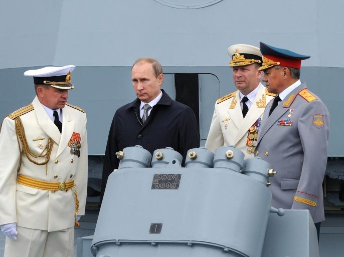 Russian President Vladimir Putin, second left, and Defense Minister Sergei Shoigu, right, with a group of Russian naval officers during a Navy parade in Baltiisk, western Russia, Sunday, July 26, 2015 during celebrations for Russian Navy Day. (Mikhail Klimentyev/RIA-Novosti, Kremlin Pool Photo via AP)