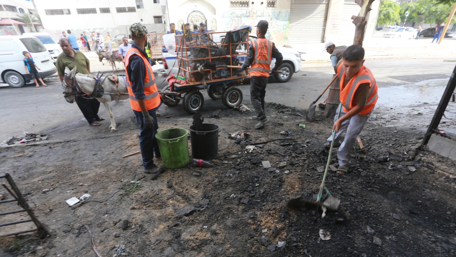‪جانب من تنظيف موقع أحد التفجيرات التي استهدفت مدينة غزة اليوم الأحد‬ (الجزيرة نت)