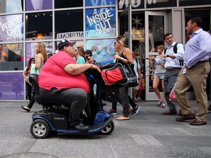 A man on an electric scooter makes his way with other pedestrians in New York on July 1, 2015. AFP PHOTO/JEWEL SAMAD