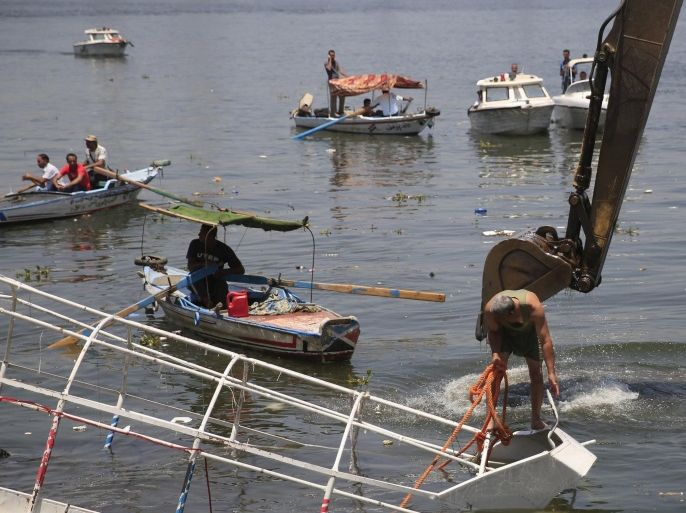 Police and fishing boats search for victims as a crane raises the boat which had capsized on the River Nile, in the Warraq area of Giza, south of Cairo, Egypt, July 23, 2015. At least 15 people drowned when the small boat collided with a barge and capsized on the Nile River near Cairo on Wednesday night, Egypt's interior ministry said in a statement. REUTERS/Amr Abdallah Dalsh