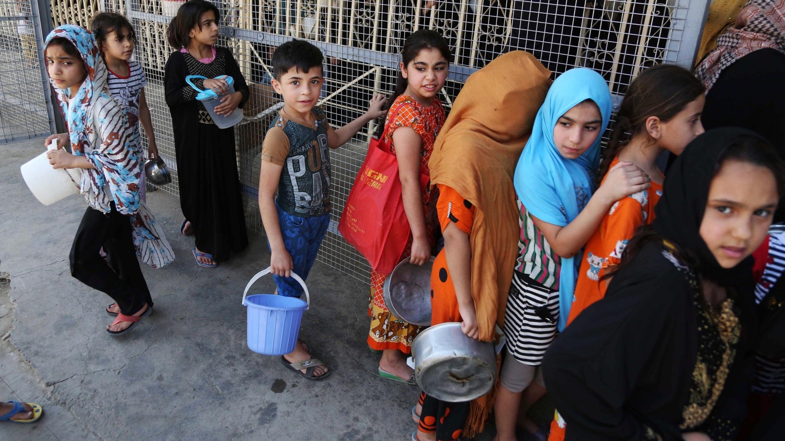 ‪أطفال نازحون في بغداد يتنظرون توزيع وجبة إطفار في رمضان 2015‬  (أسوشيتد برس)